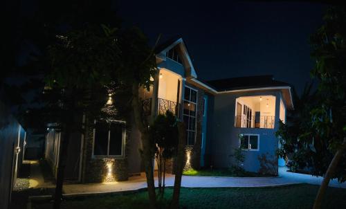 ein nachts beleuchtetes Haus mit Licht in der Unterkunft Short And Long Stay Six Bedroom Apartment in Tema