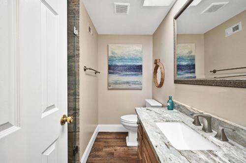 a bathroom with a sink and a toilet at Newport Paradise - Oceanfront Home by the Pier in Newport Beach