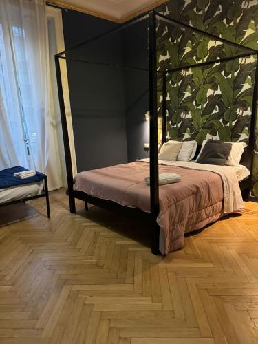 a bedroom with a canopy bed and a wooden floor at Family Hostel Milano in Milan