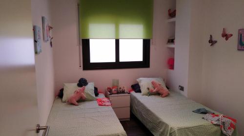 two beds in a room with green and pink at Apartaments Oller 2 in Roses