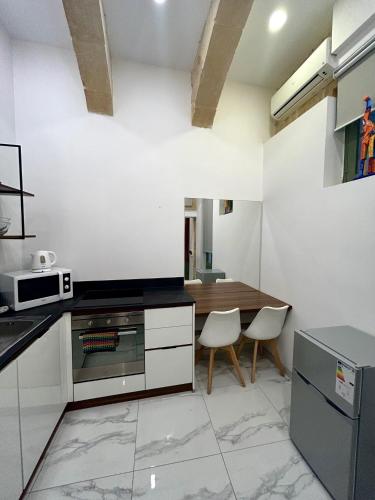 a kitchen with a table and two chairs in it at Tritoni Harbour suites - Valletta in Valletta