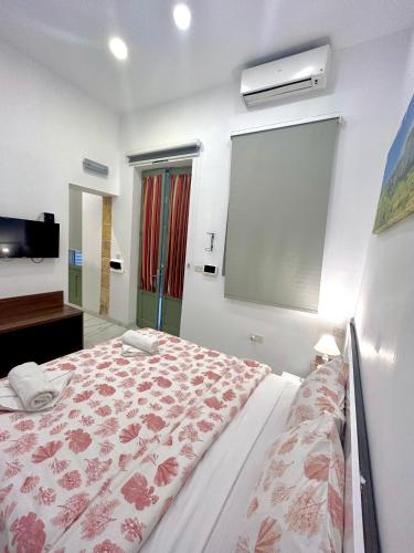 a bedroom with a large bed with a flowered blanket at Tritoni Harbour suites - Valletta in Valletta