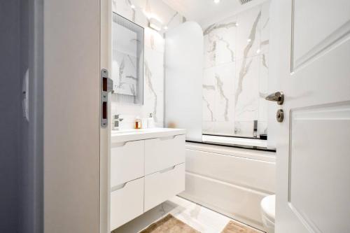 a white bathroom with a sink and a mirror at Top 10 3br2bh Jacuzzi Free Parking in Sofia