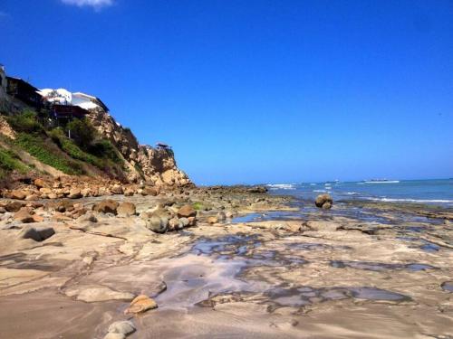 a sandy beach with rocks and the ocean at Departamento Mar de Cristal in Santa Elena