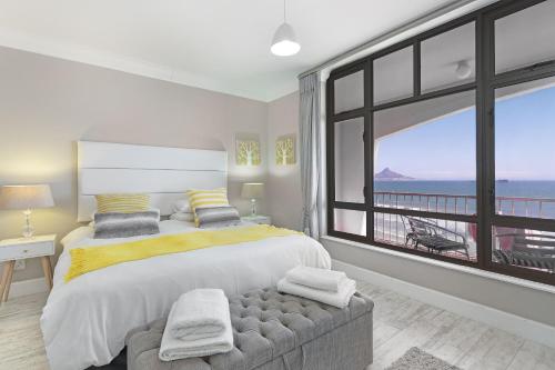a bedroom with a large bed and a large window at Witsand 804 by Host Agents in Bloubergstrand