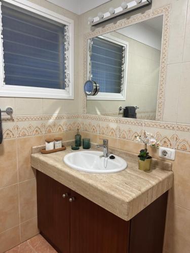 a bathroom with a sink and a mirror at Luminoso apartamento con amplia terraza y vistas in Candelaria