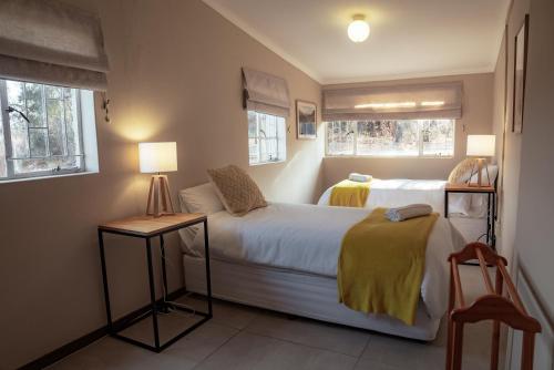 1 dormitorio pequeño con 2 camas y 2 ventanas en Eco Farm Cottage en Millvale