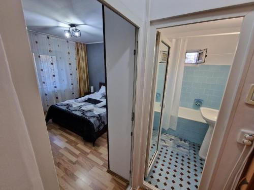 een slaapkamer met een bed en een badkamer met een spiegel bij DurAsset Home in Ploieşti