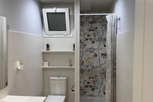 een badkamer met een douche, een toilet en een televisie bij Centrico piso en Tarragona in Tarragona