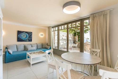 ein Wohnzimmer mit einem Sofa und einem Tisch in der Unterkunft Villa Anemoni by Mykonian Kazarte in Kalafatis
