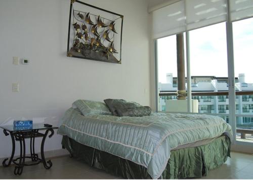 ein Schlafzimmer mit einem Bett und Blick auf die Stadt in der Unterkunft Casa Mccraren Torre 3-302 at Mayan Lakes in Playa Encanto