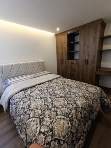 ein Schlafzimmer mit einem Bett mit einer Bettdecke in der Unterkunft Apto 1008 RB Increíble inmueble in Tunja