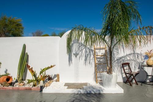 a white wall with a palm tree and a ladder at Antonakis Villa Rhodes Private Pool & Jacuzzi Retreat in Kremasti