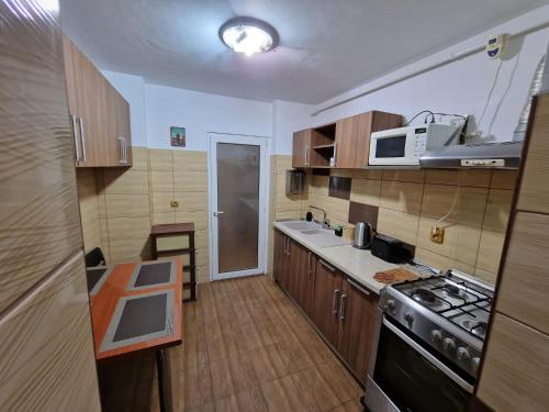 een keuken met houten kasten en een fornuis met oven bij DurAsset Home in Ploieşti