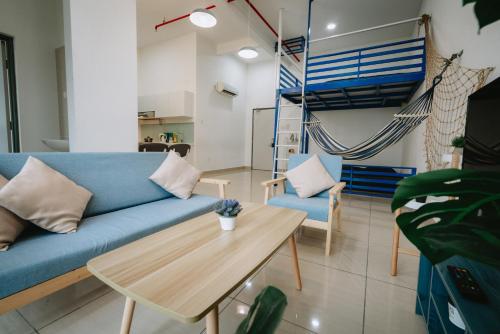 a living room with a blue couch and a table at Mount Austin Manhanttan Sovo by Cactus Homestay in Johor Bahru