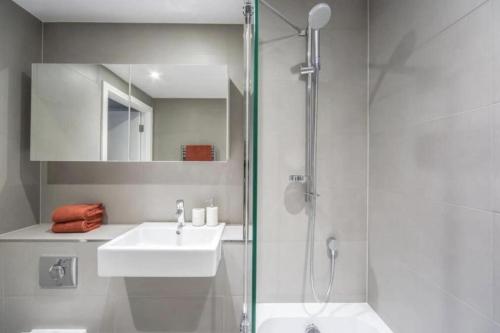 a white bathroom with a sink and a shower at 2 Bedroom 2 Bathroom Cosy Apartment - Zone 1 - Central London in London