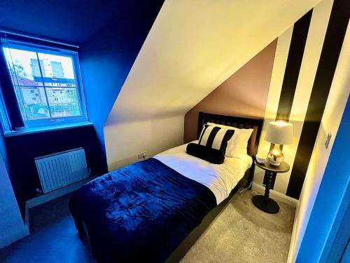 a blue bedroom with a bed with a black and white striped wall at Lotus Haus - Wyndale Living -W/off road Parking in Birmingham