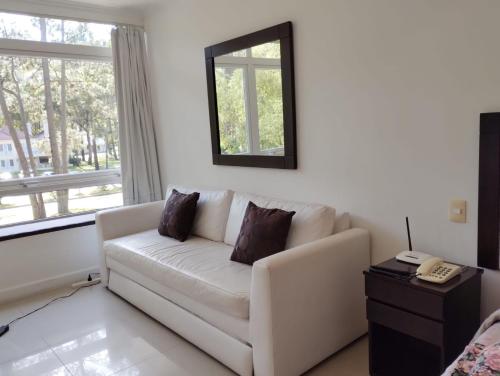 a living room with a white couch and a window at Green Park Departamentos Exclusivos in Punta del Este