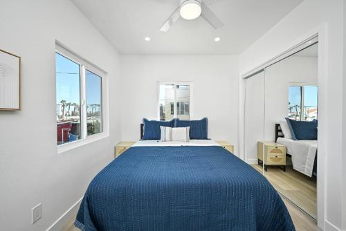 a bedroom with a large bed with blue sheets at Sunset Beach Retreat next to Water Tower and Ocean in Sunset Beach