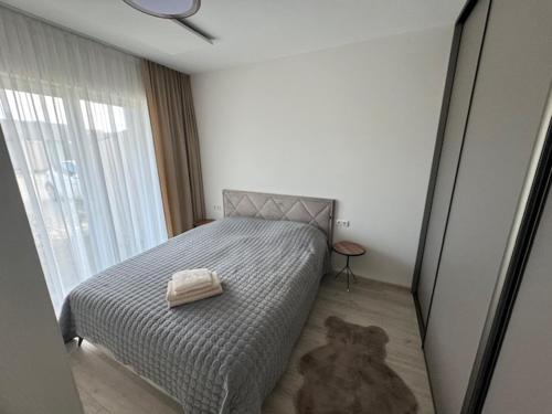a bedroom with a bed with a towel on it at Mano jura 2-Apartments in Palanga