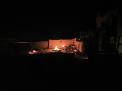 a room with a fire in the dark at La Siwa in Siwa