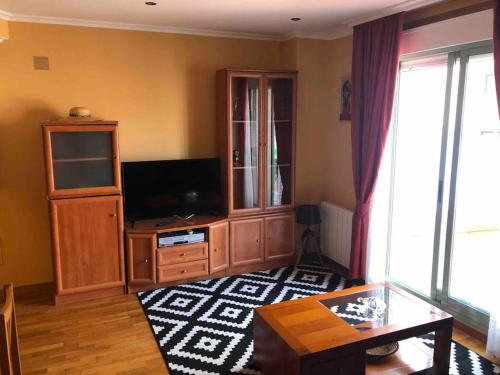 ein Wohnzimmer mit einem TV und einem Entertainment-Center in der Unterkunft Ponteareas Precioso apartamento . VUT-PO-011959 in Ponteareas