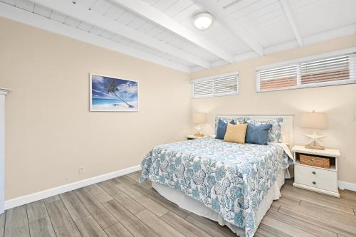1 dormitorio con 1 cama con colcha azul en 2 Bedroom Upstairs Apt 1 block from the beach! en Newport Beach