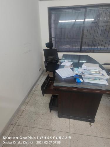 an office with a glass desk with papers on it at JA INT in Dhaka