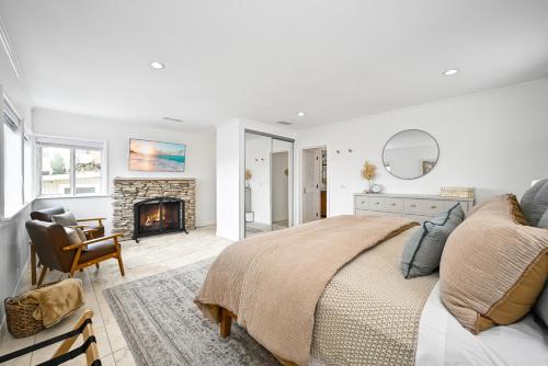 a white bedroom with a bed and a fireplace at 1313 S Coast Hwy in Laguna Beach