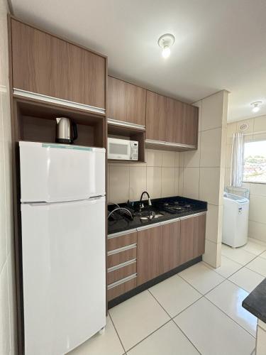 a kitchen with a white refrigerator and a microwave at Apartamento 246 in Rio Negrinho
