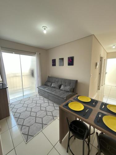 a living room with a couch and a table and chairs at Apartamento 246 in Rio Negrinho