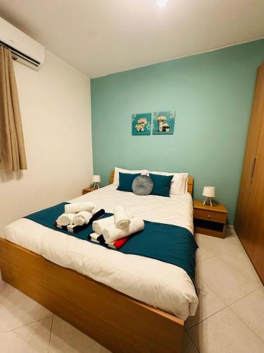 a bedroom with a large bed with towels on it at Wardina Holiday Home Maisonette in Munxar