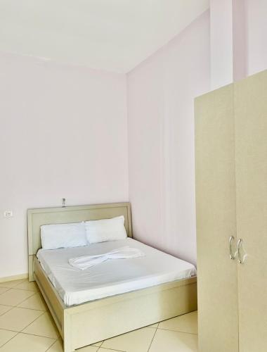 een klein bed in een kamer met witte muren bij Hotel Tani 