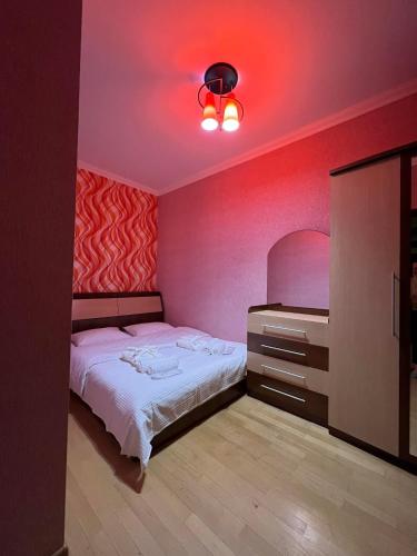 - une chambre avec un lit et une lumière rouge dans l'établissement mimi, à Tbilissi