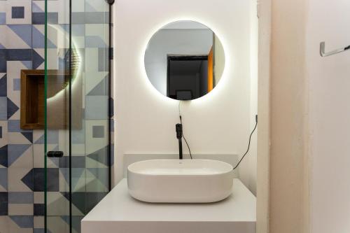 a bathroom with a white sink and a mirror at CykelHaus Studios in Sao Paulo