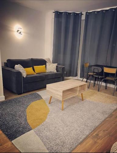 a living room with a couch and a coffee table at Le Nuage de Jaude II in Clermont-Ferrand