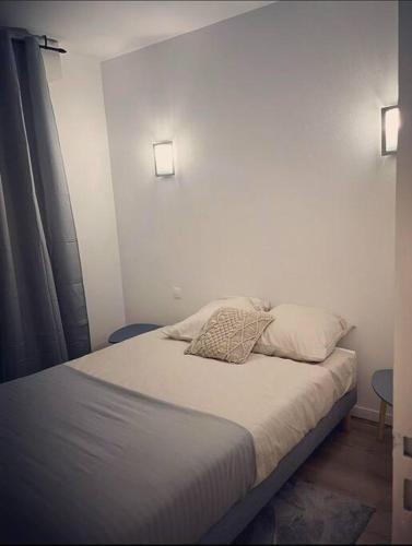 un lit avec deux oreillers dessus dans une chambre dans l'établissement Le Nuage de Jaude II, à Clermont-Ferrand