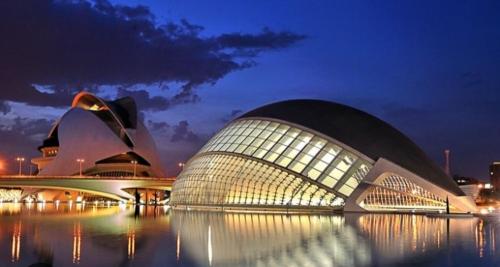 a large building at night with its lights on at Buen Estar, piscina, barbacoa, jacuzzi en Valencia in Turís