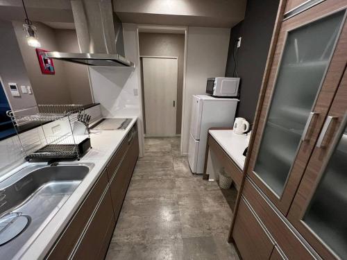 a small kitchen with a sink and a refrigerator at HOTELMr,KINJOin PREMIUMTERRACECHATAN - Vacation STAY 59237v in Chatan