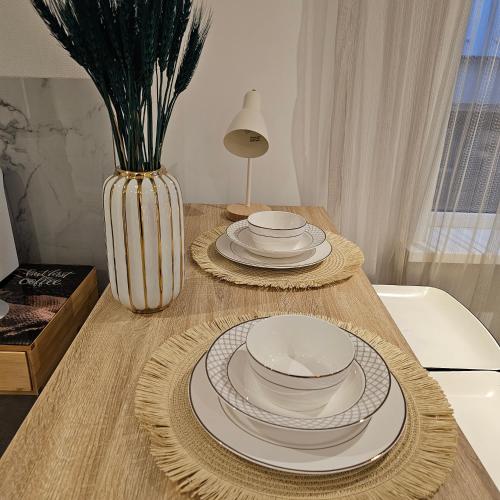 a wooden table with plates and a vase on it at Il Mulino House A in Lisse