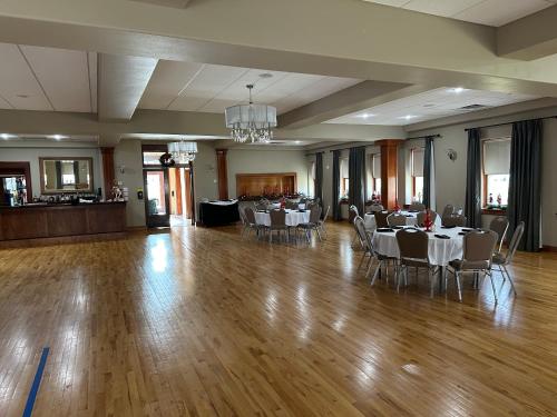 een feestzaal met witte tafels en stoelen en een kroonluchter bij Buffalo Ridge Resort and Spa in Gary