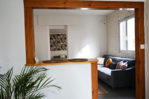 ein Wohnzimmer mit einem blauen Sofa und einem Spiegel in der Unterkunft Maison de ville - Chelles Close to Disney & Paris in Chelles