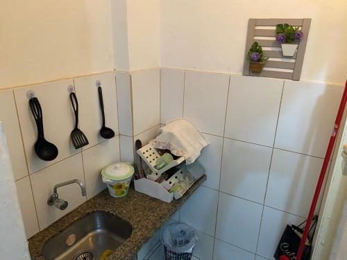 um balcão de cozinha com um lavatório e utensílios em Studio Centro em Porto Alegre