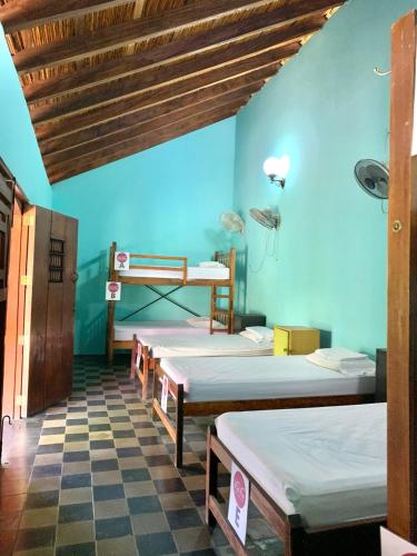 a room with four beds and a blue wall at ViaVia Leon in León