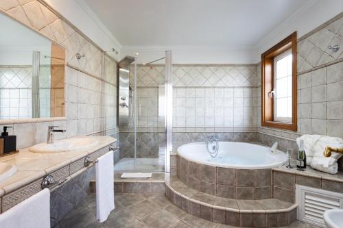 een badkamer met een bad, 2 wastafels en een douche bij Casa Lali Habitación 1 in La Laguna