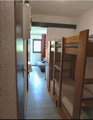 une chambre avec des lits superposés et un couloir avec une chambre avec des lits superposés dans l'établissement Appartement pied des pistes, à Modane