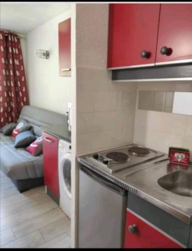 - une petite cuisine avec une cuisinière et un canapé dans la chambre dans l'établissement Appartement pied des pistes, à Modane