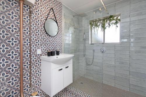 a bathroom with a white sink and a mirror at Sea Spray B104 in Table View
