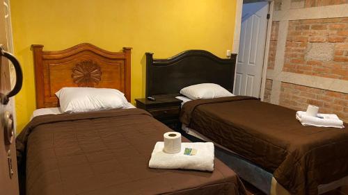 a hotel room with two beds with towels at Casa colonial in Quetzaltenango