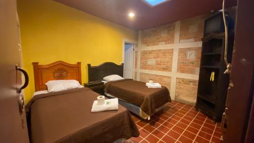 um quarto de hotel com duas camas e uma televisão em Casa colonial em Quetzaltenango